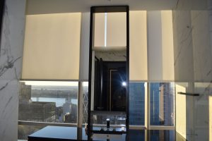 Motorized roller shades in a high-rise